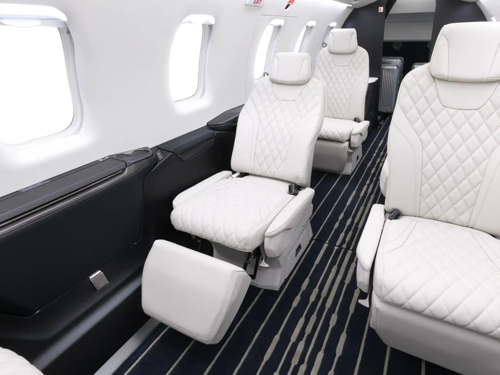 The PC-24 cabin shows an extended seat, with the footrest raised and the backrest lowered
