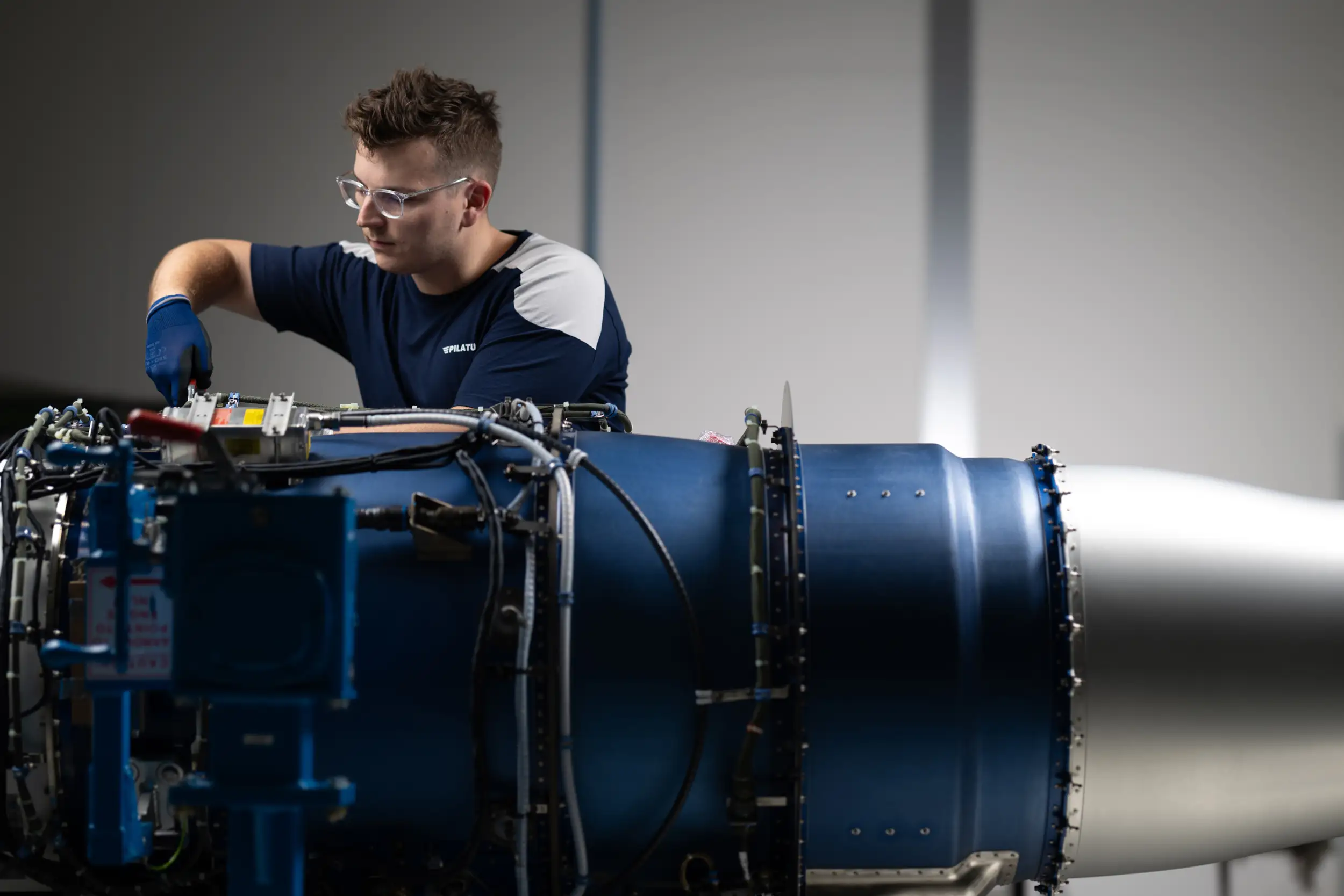 An employee is working on an engine.