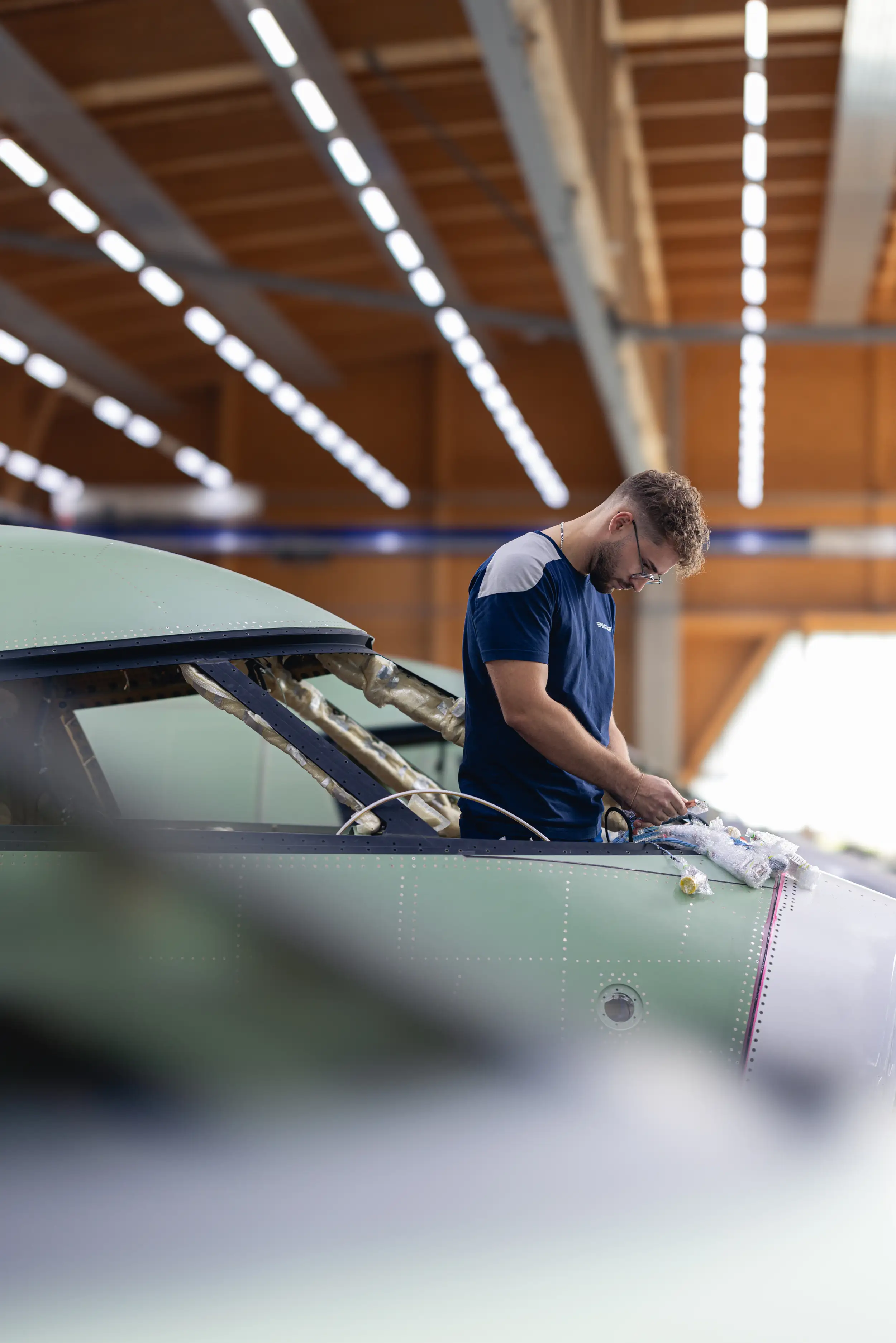 An employee is working on the aircraft.